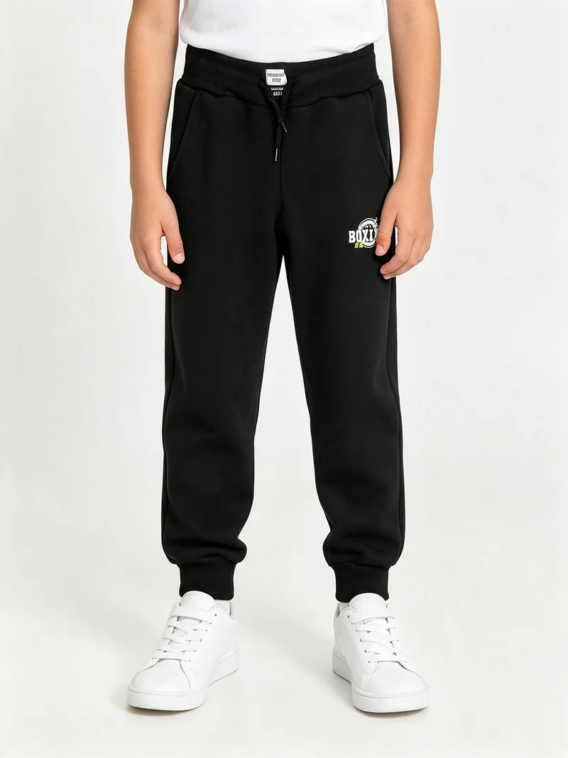 Pantaloni tuta da ragazzo in felpa con coulisse e polsini - nero