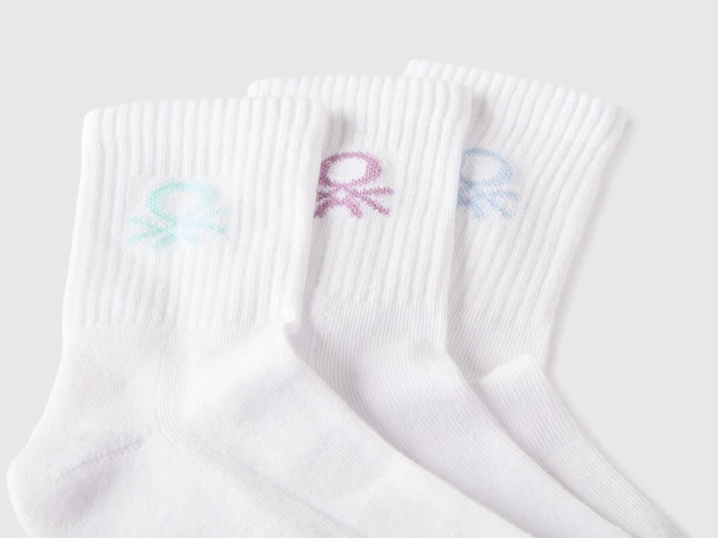 Drei weiße Socken mit farbigem Logo