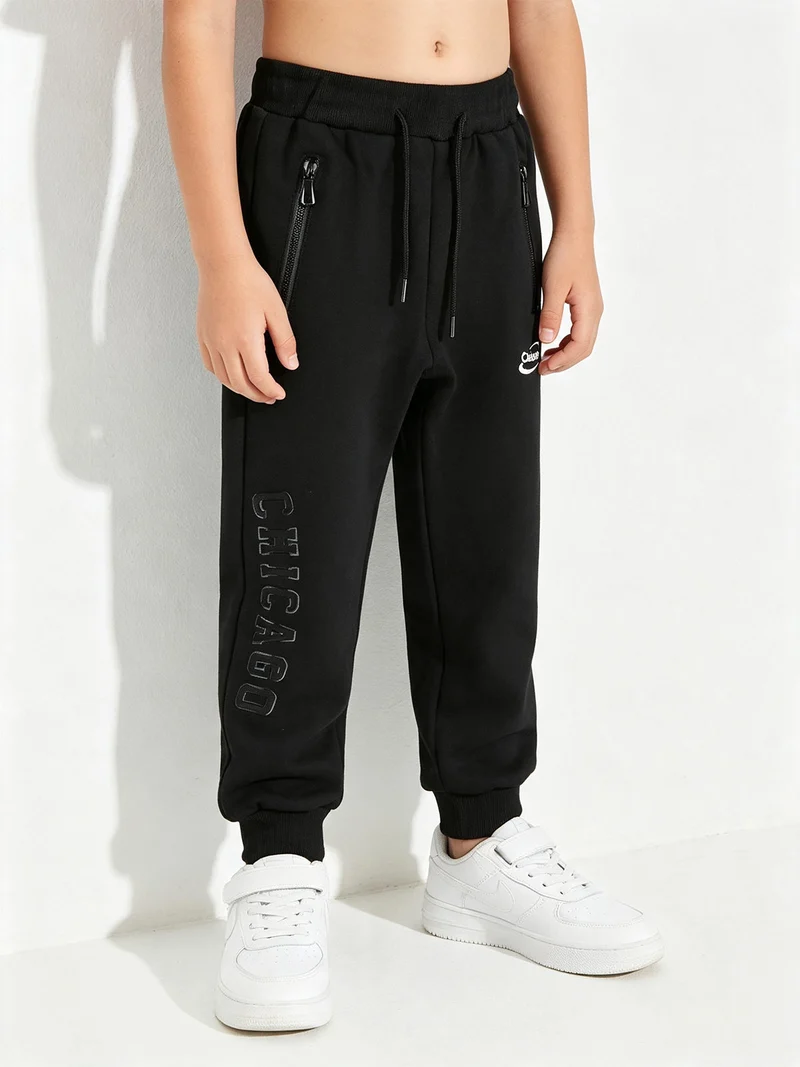 Pantaloni tuta da bambino con polsini e coulisse - nero