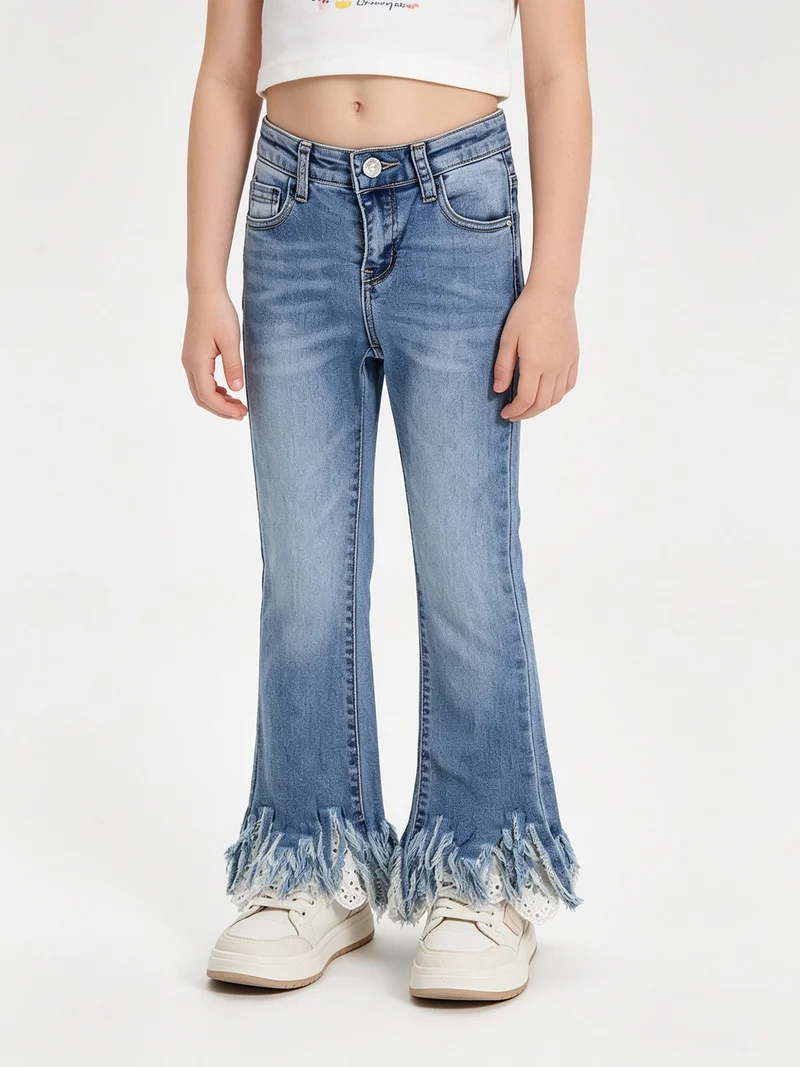 Jeans crop da bambina con finale a zampa sfrangiato in macramè - jeans