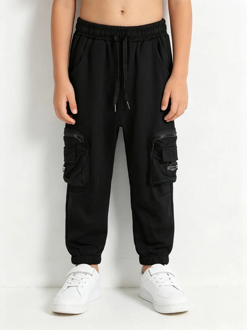 Pantaloni tuta da bambino con tasconi laterali e polsini - nero