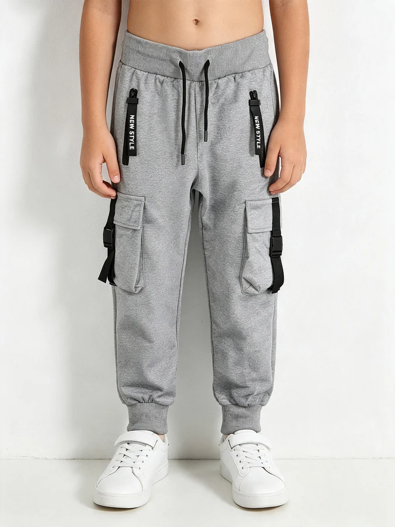 Pantaloni tuta da bambino con tasconi laterali e polsini - grigio