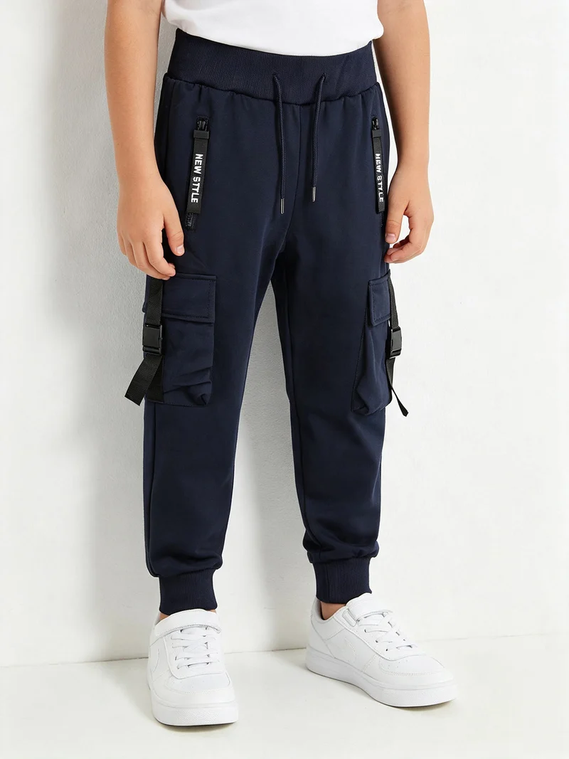 Pantaloni tuta da bambino con tasconi laterali e polsini - blu scuro
