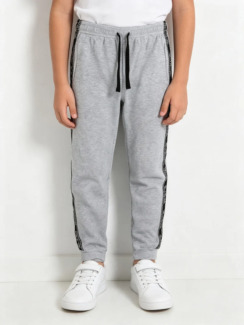 Pantaloni tuta da ragazzo felpati con striscia laterale - grigio