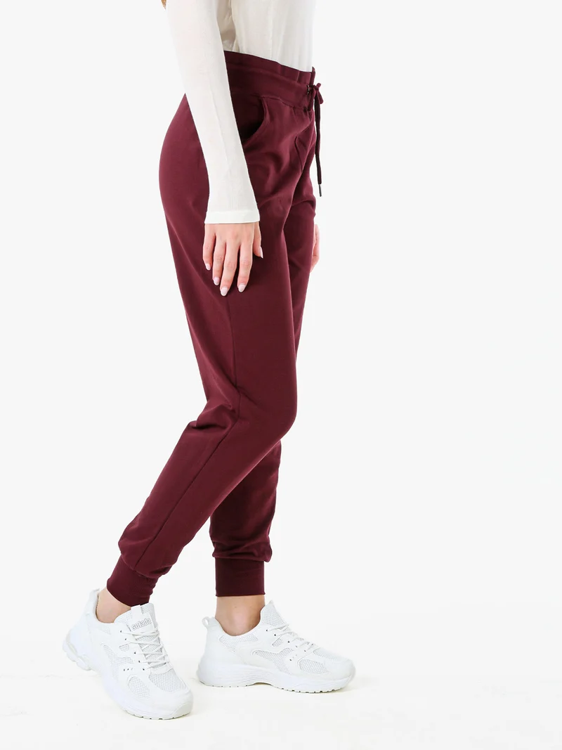 Pantaloni tuta da donna in cotone con coulisse e polsini - bordeaux