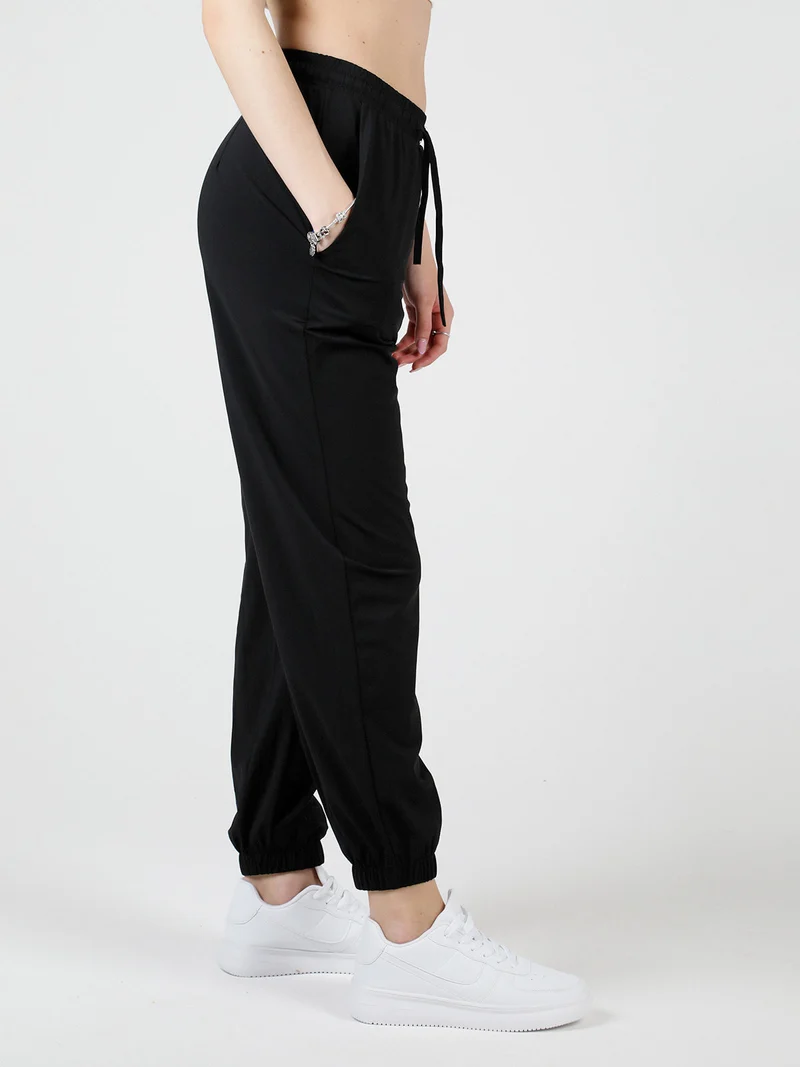 Pantaloni donna in tessuto tecnico con polsini - nero